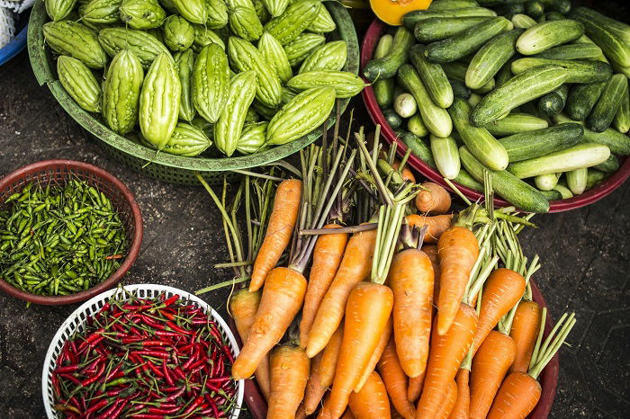 Food styling: a bunch of carrots cucumbers and assorted chilis 