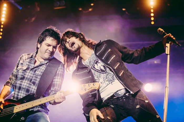 A close up of a guitarist and singer onstage during a live gig