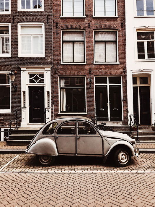 Photo of an old car in front of a brick building