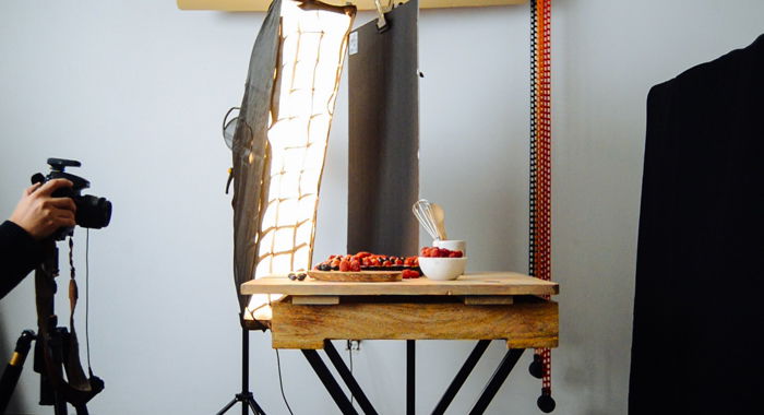 photo of a low lighting setup with plates of fruit on a table