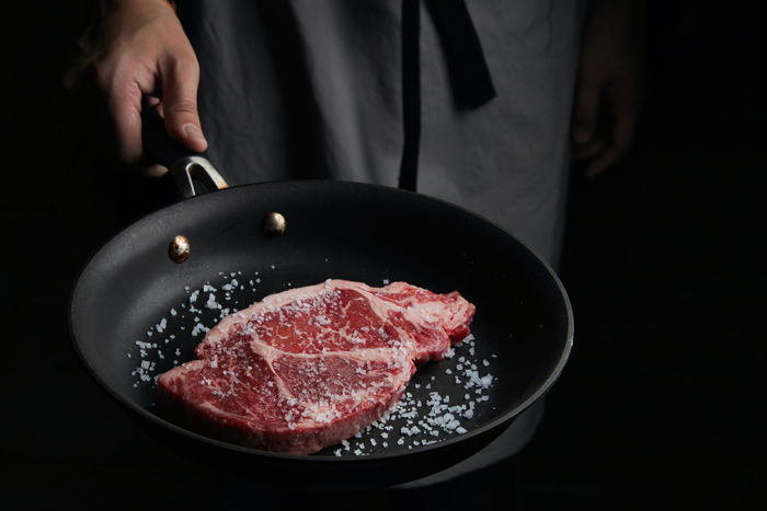 Cooking a juicy steak in a frying pan