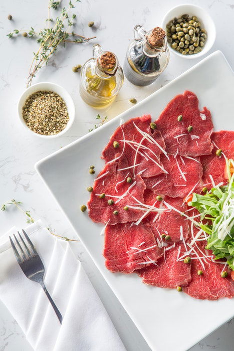 Overhead view of thinly sliced meat and condiments