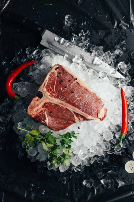 Flat lay of a cut of raw meat on ice