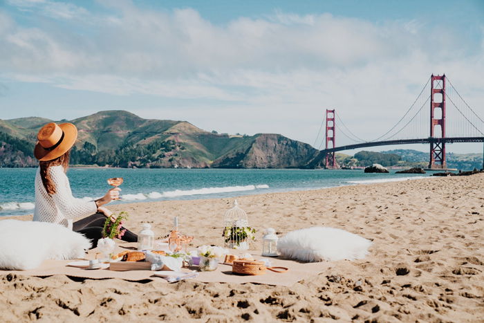 A girl posing for a lavish picnic photoshoot on a beach