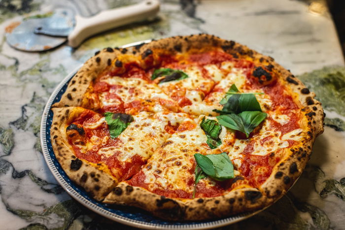 Photo of a pizza with basil leaves on top