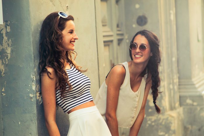 Candid portrait of two girls chatting outdoors