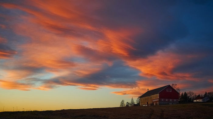 Streaky colorful clouds above a house at golden hour