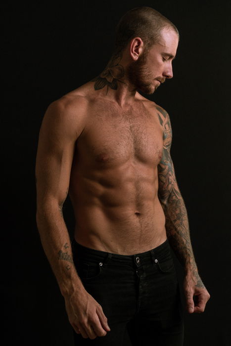 photo of a half naked male model with a black background