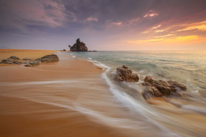 Wave rolling onto a beach at evening time