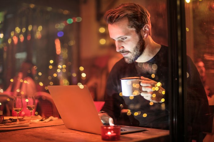 A man using his laptop in a cafe