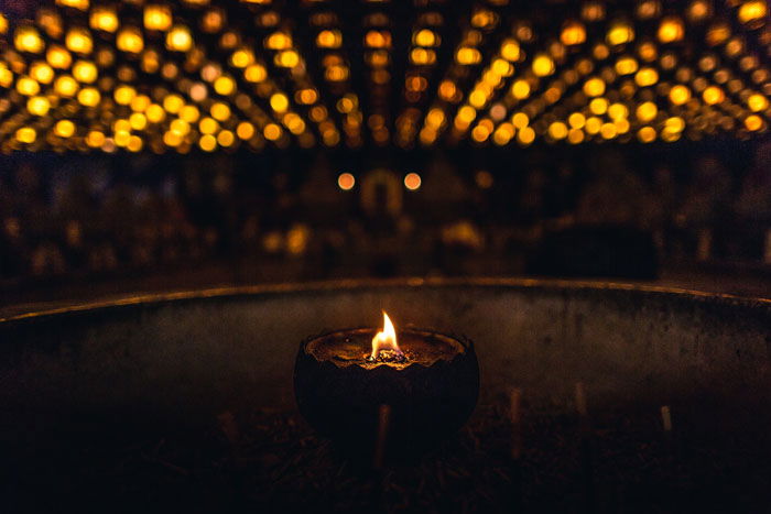 A close up of a tealight candle in a dark room