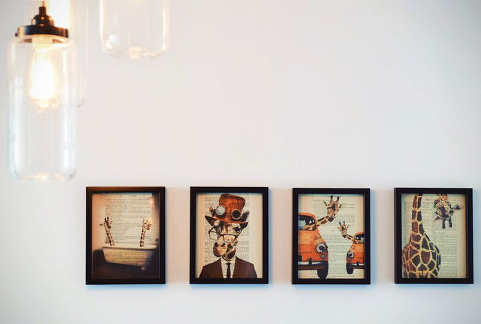 Four framed prints of quirky artwork on a wall 