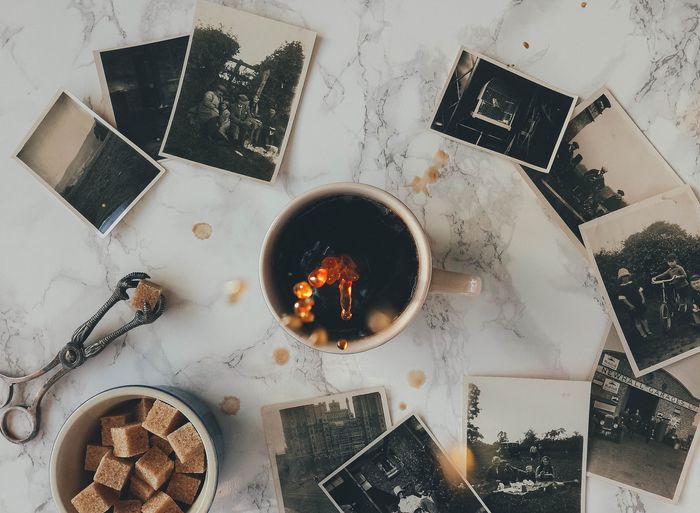 Coffee Splash Photography: overhead photo of a coffee mug on a table with black and white polaroid photos