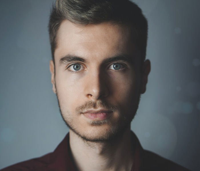 A close-up a young man using a 1 light setup for portraits