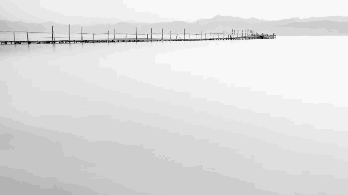 Minimal photo of a dock in Kalamaki beach at dawn in Kerkyra Greece demonstrating smooth motion blur