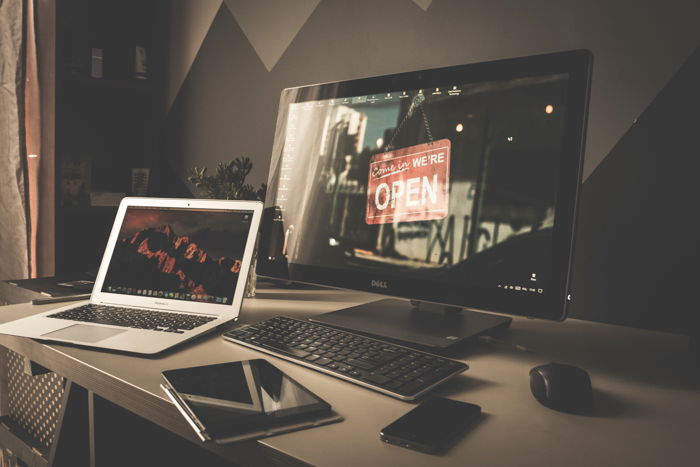 A picture of a desk with devices like a laptop and monitor