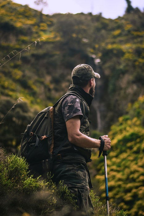 A camouflaged nature photographer on a hike in the wilderness