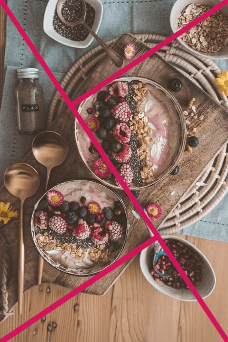 Two desserts, some berries, a spoon, and an ingredient jar, set against a rustic wooden background. 