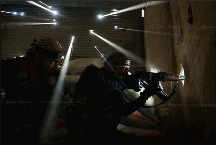 Two men in military uniforms in a dimly lit room. 