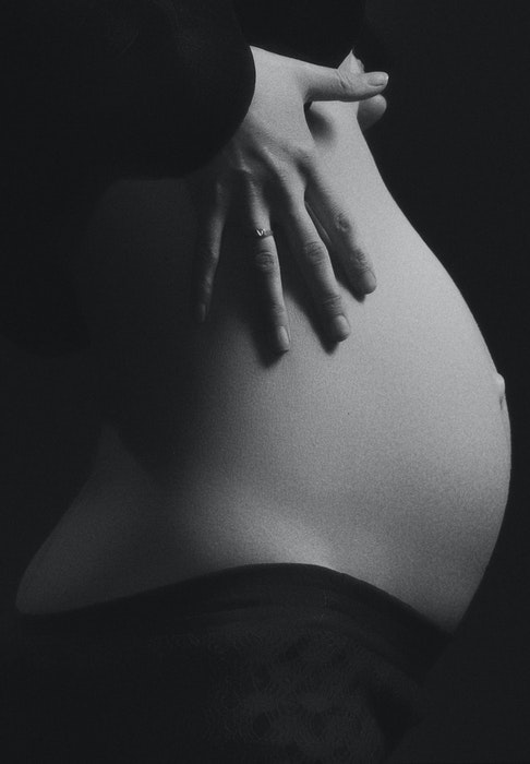 Abstract close-up of a woman's round belly for pregnant boudoir photography