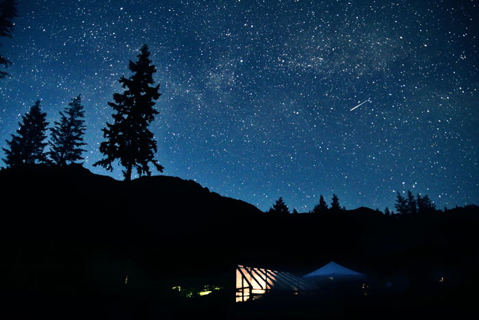 meteor shower captured over dark landscape