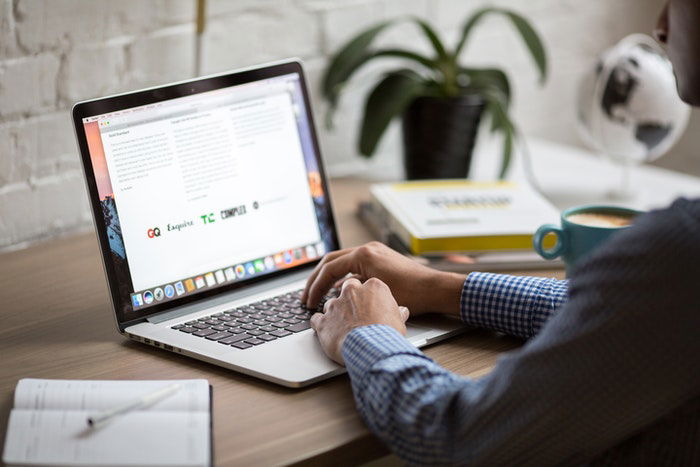 A man writing a real estate photography contract on a laptop