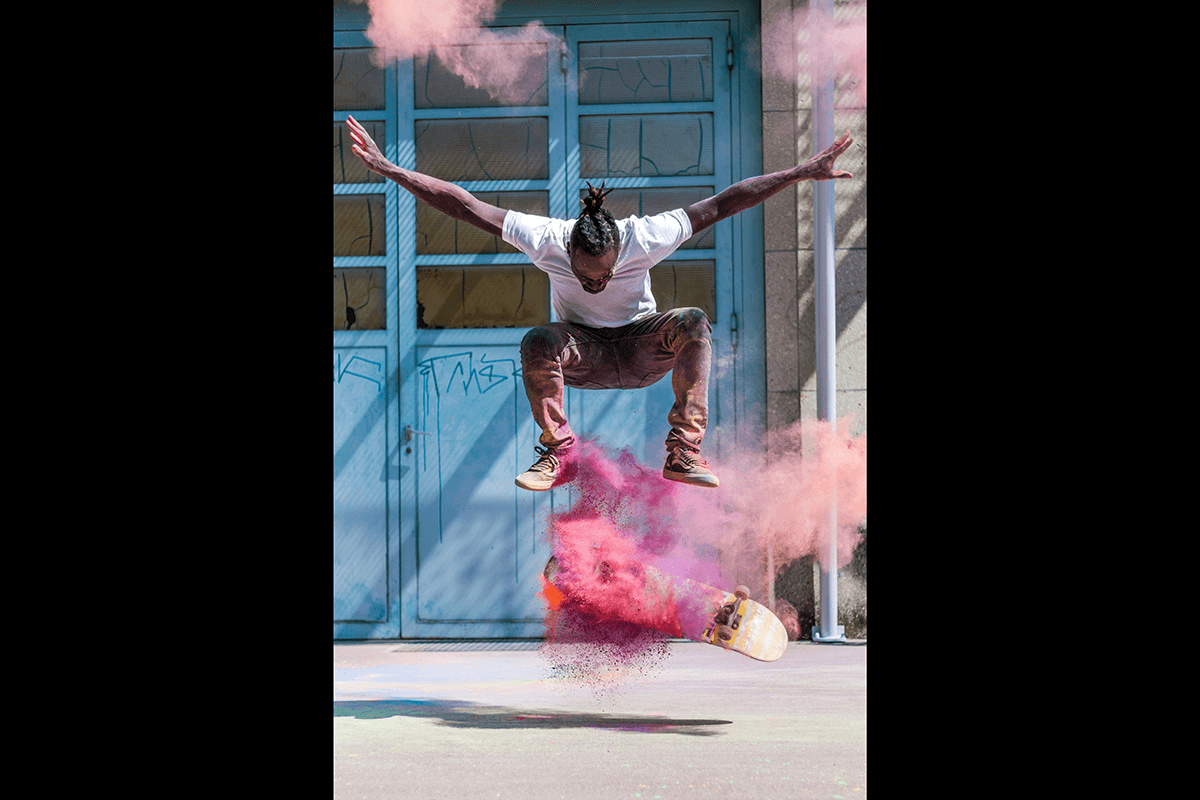 Skateboarder doing a trick with a smoke bomb as an example of skateboard photography