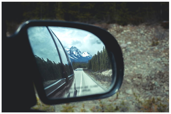 photo of a mountain reflected in a car mirror 