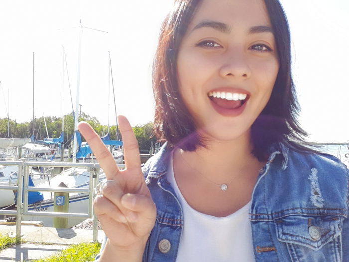 A girl giving V finger sign outdoors