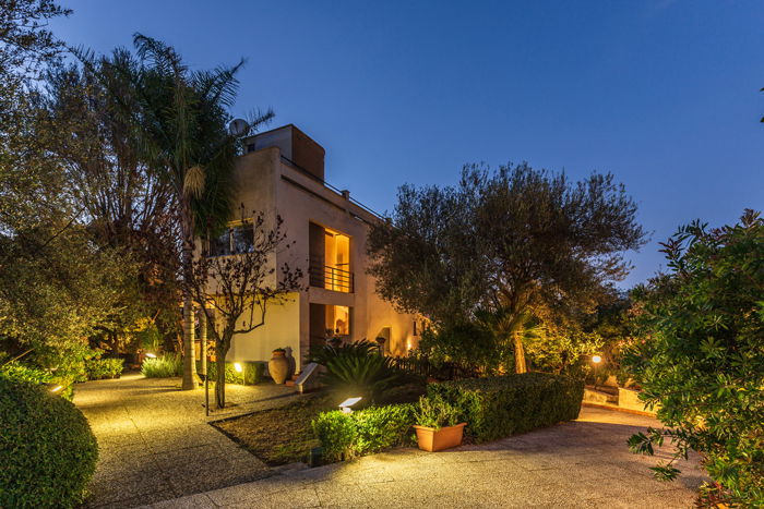 a twilight photo of a modern house and garden