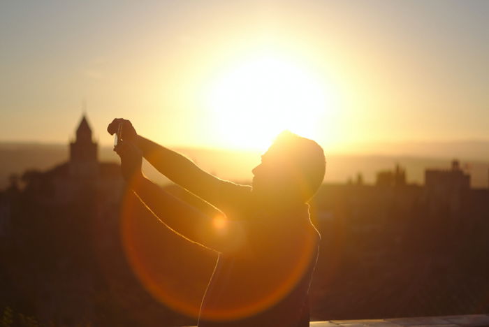 an image of a man on a rooftop with backlighting and lens flare