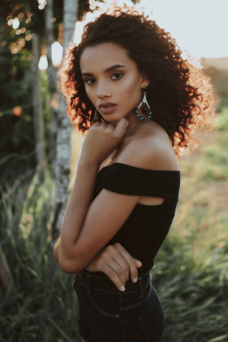 an image of a woman posing in a field with backlighting