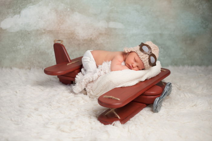 newborn baby posing on an interesting airplane prop