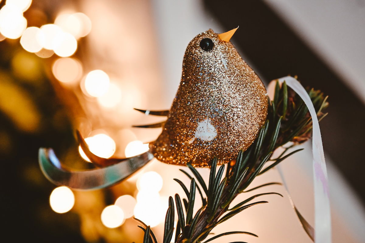 Close-up of a Christmas tree ornament with lights in the background