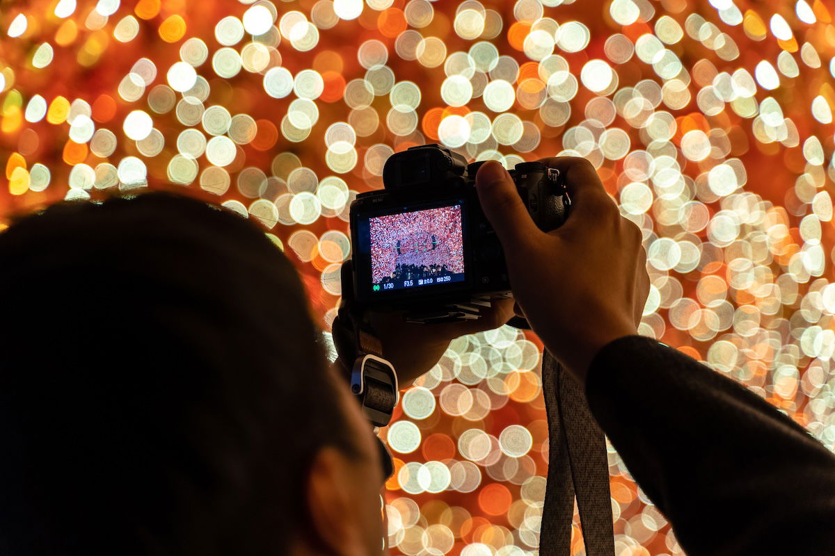 A photographer picking camera settings for Christmas lights