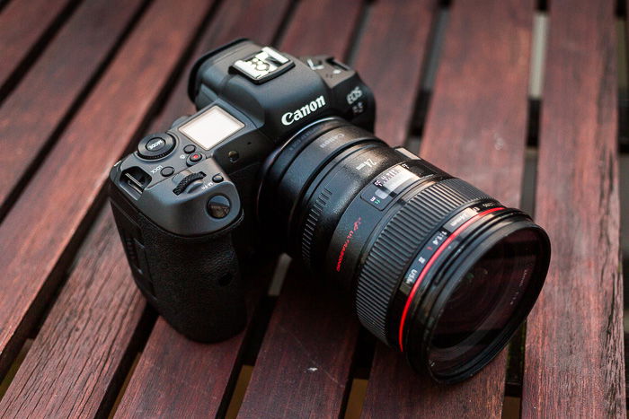 A Canon camera and lens mounted on it, with the camera placed on a wooden surface. 