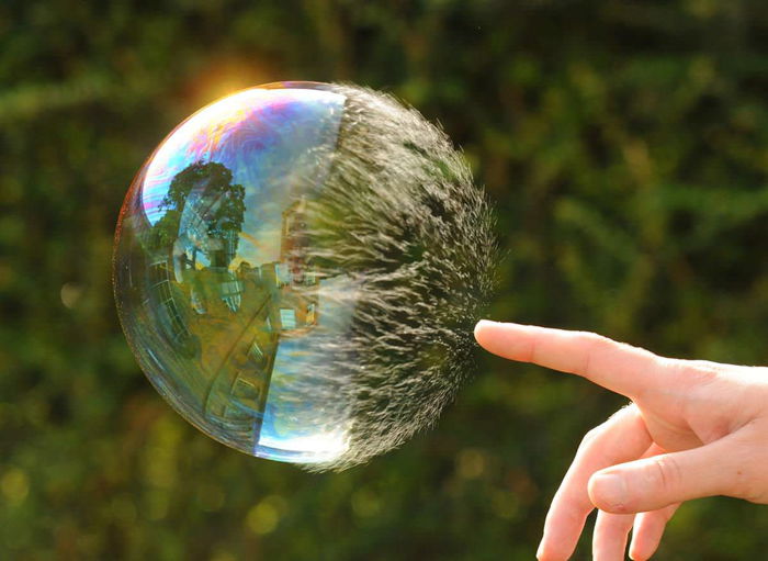 A person touching a huge bubble