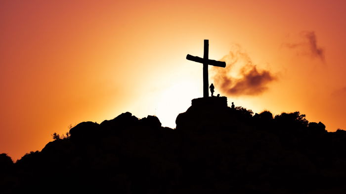 Cool silhouette photography of a girl beside a giant cross on a mountain at sunset