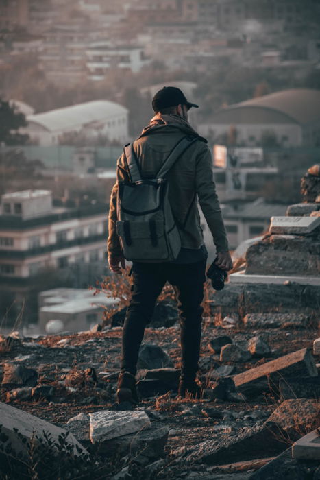 an image of a male photographer from behind holding a camera in his right hand