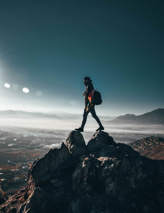 an image of a man standing at the summit of a mountain