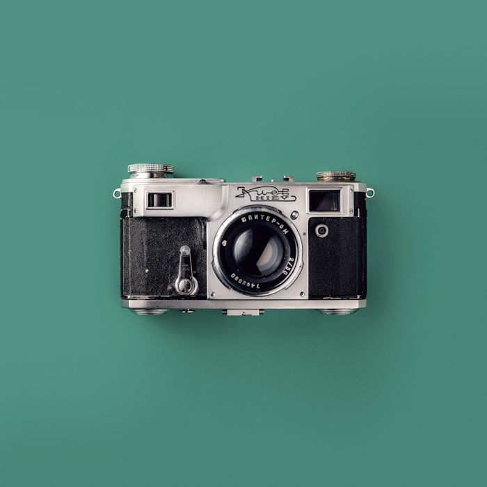 Grey and Black Rangefinder Camera On Green Background