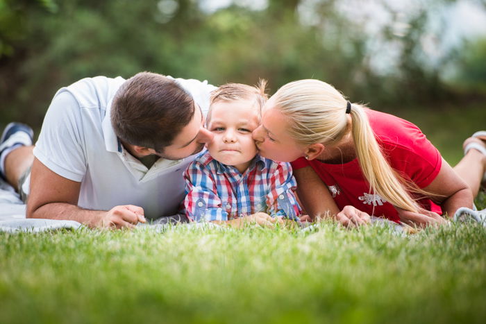 family portrait poses mother father and child laying down in the grass