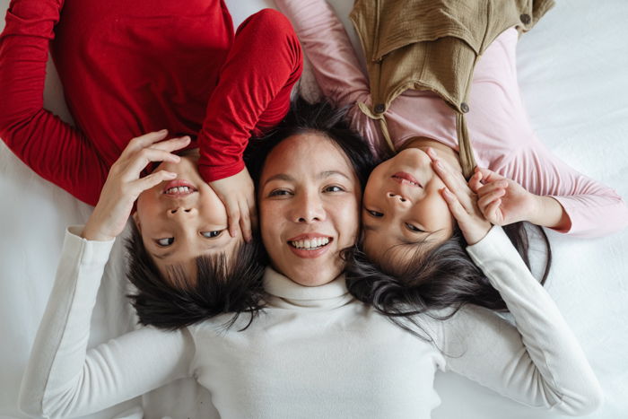 three women photographed on bed from above