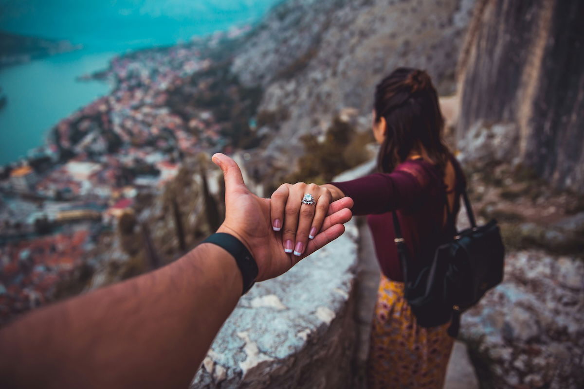 A woman leading a photographer by the hand as a Valentines day photoshoot idea