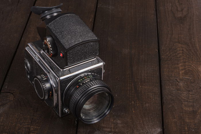 A medium format film camera on a wooden table