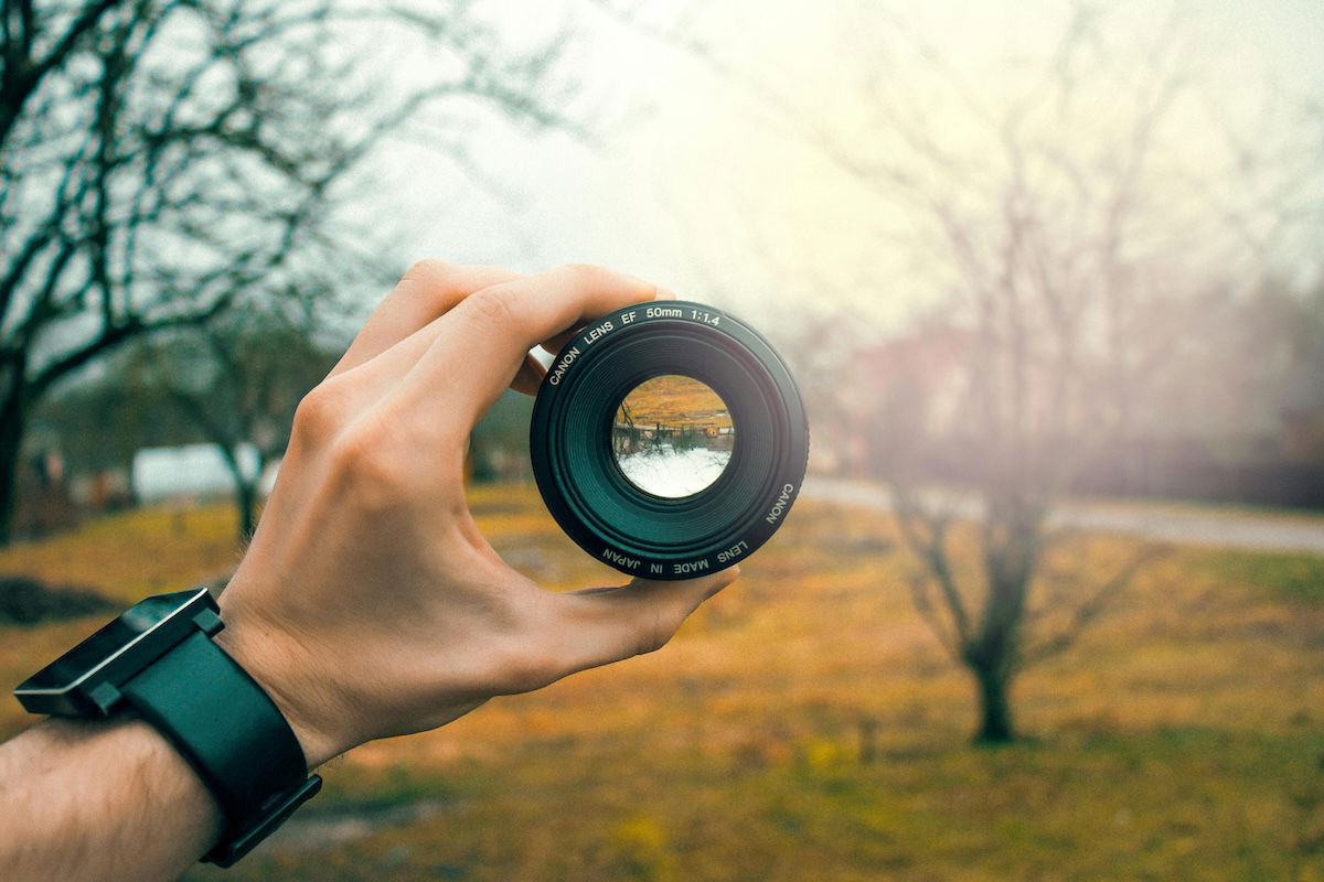 A photo with a shallow depth of field of a person holding up a nifty fifty lens