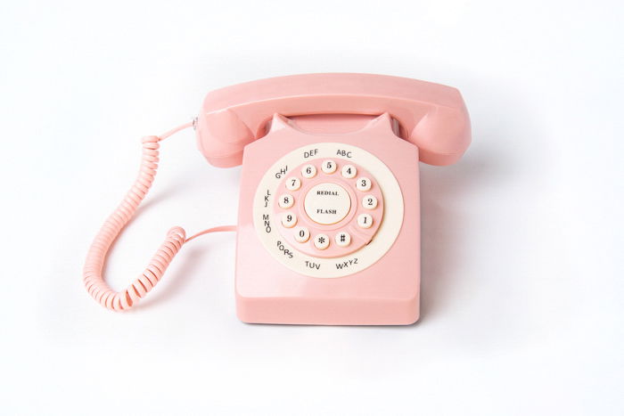 An analog phone against a white background with infinty curve background