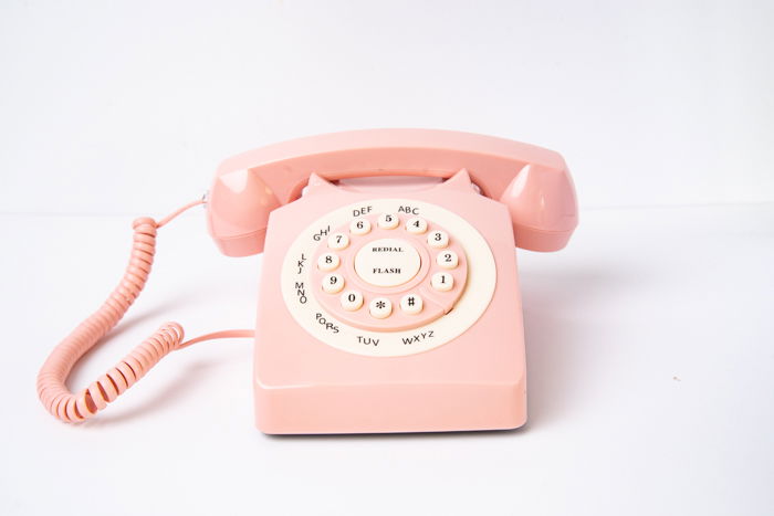 An analog phone against a background with seams