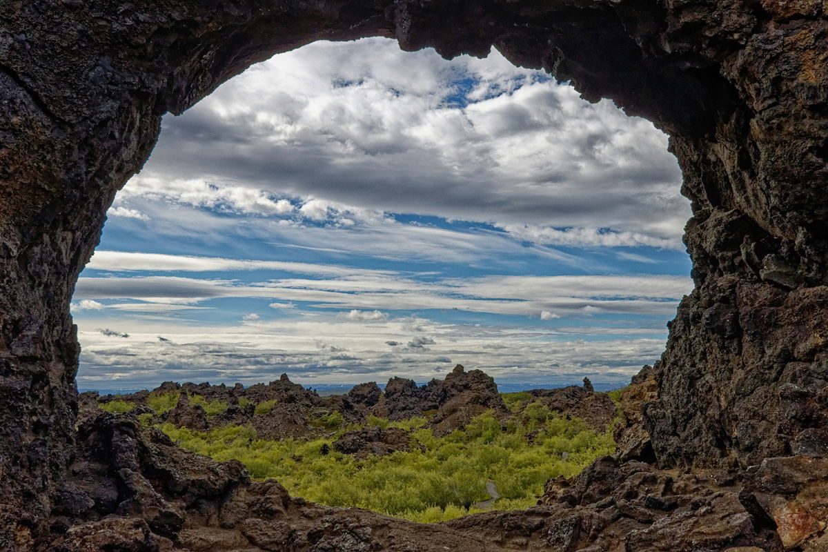 A rock formation creating a natural frame for a landscape with visual weight