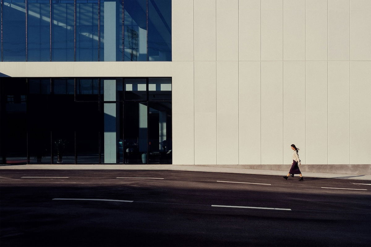 A street photo of a person walking in front of a building showing visual weight